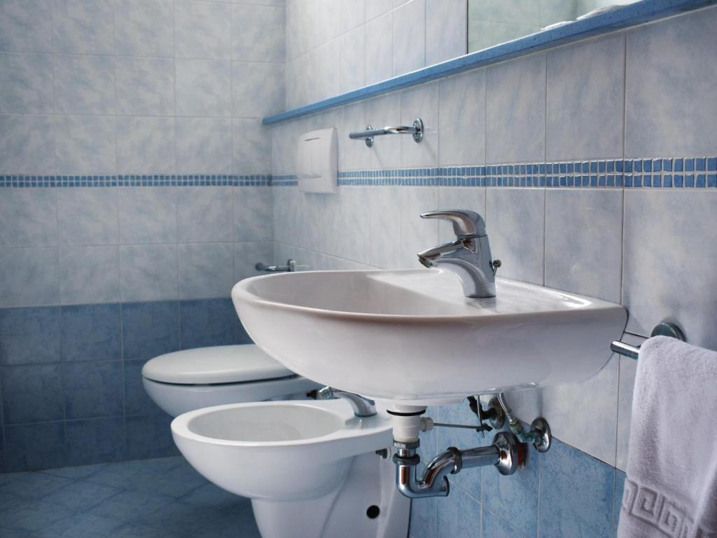 une salle de bain avec un lavabo et des toilettes dans l'établissement Hotel Bamby, à Rimini