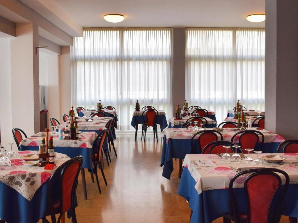 une salle à manger avec tables et chaises et nappes bleues dans l'établissement Hotel Bamby, à Rimini