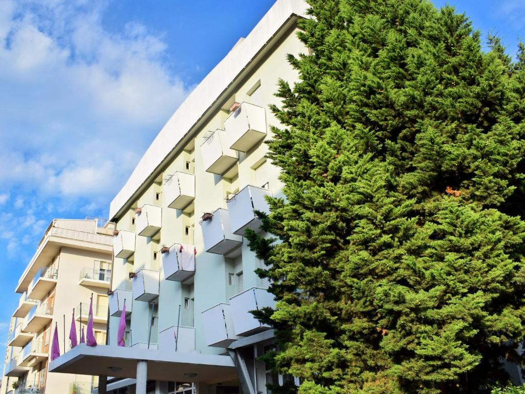 un bâtiment avec un arbre devant lui dans l'établissement Hotel Bamby, à Rimini