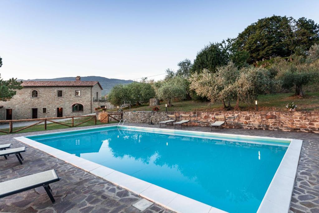 une piscine devant une maison dans l'établissement Agriturismo Le Celle, à Cortone