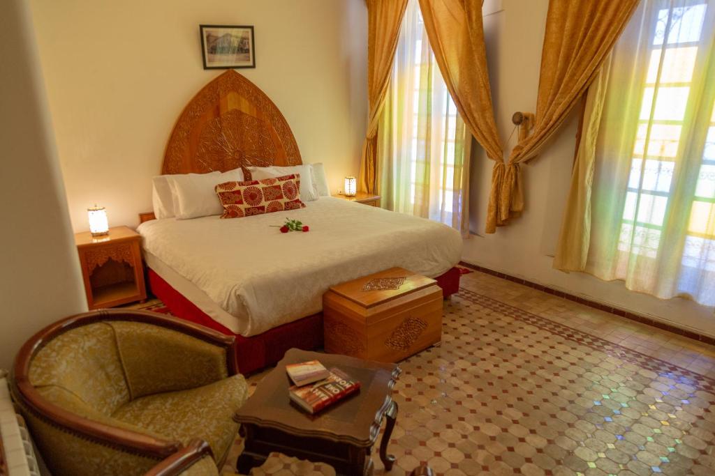 une chambre avec un lit et une chaise dans une pièce dans l'établissement Riad Tahra & Spa, à Fès