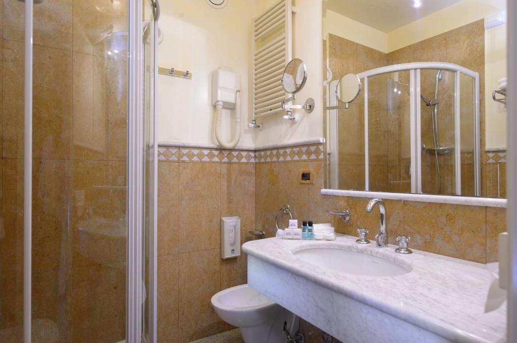une salle de bain avec toilettes, lavabo et douche dans l'établissement Hotel Bristol, à Sottomarina