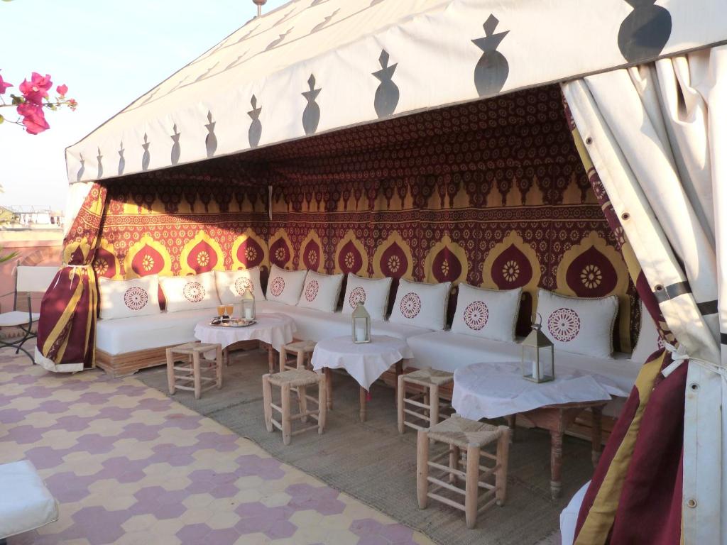 une tente avec des tables et des chaises blanches sous celle-ci dans l'établissement Riad Habib, à Marrakech 37 autres photos