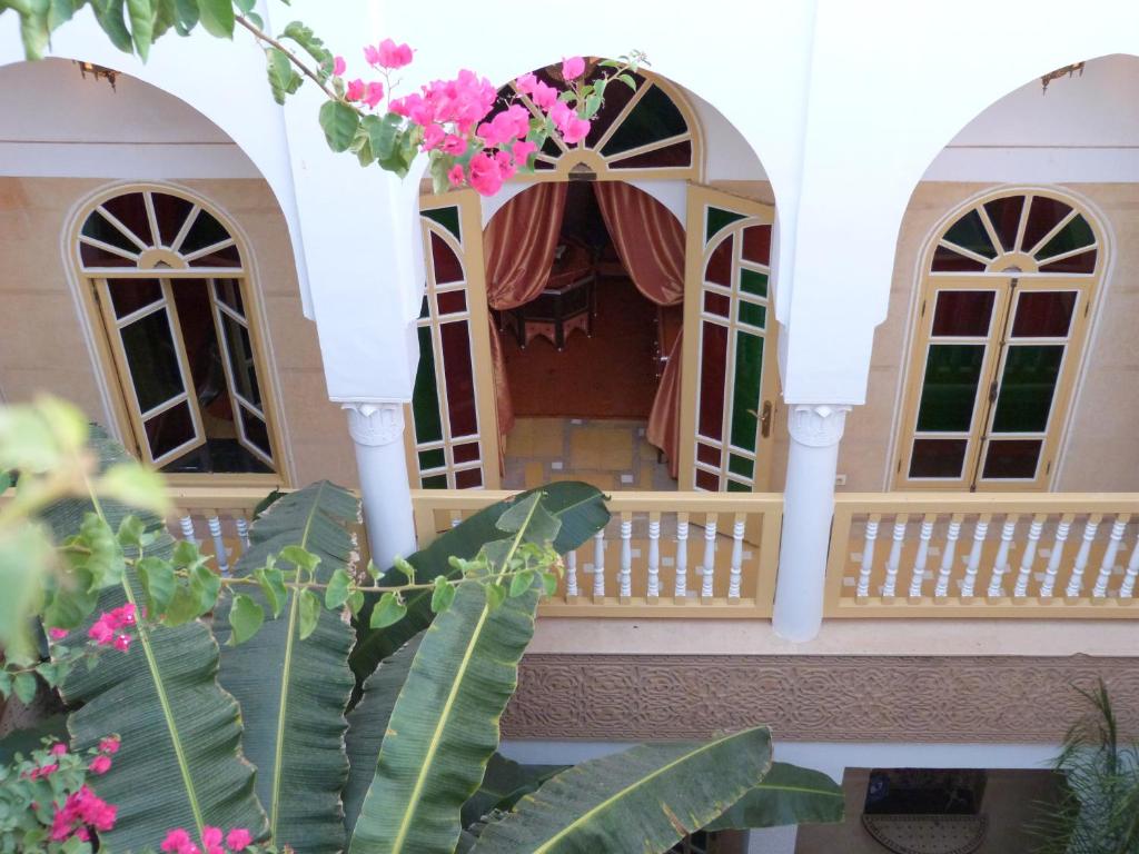 un modèle de maison avec terrasse couverte et fleurs roses dans l'établissement Riad Habib, à Marrakech
