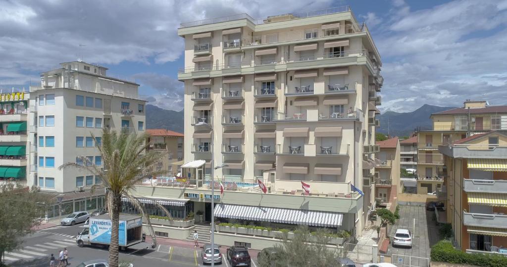 un grand bâtiment blanc dans une ville avec des bâtiments dans l'établissement Hotel Residence Villa Jolanda, à Lido di Camaiore