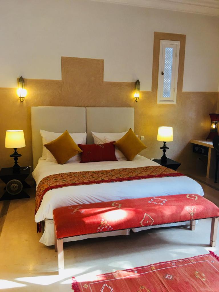 - une chambre avec un grand lit et un banc rouge dans l'établissement Riad des Golfs, à Agadir 37 autres photos
