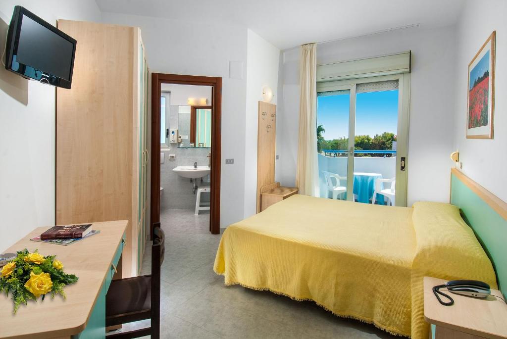 Cette chambre d'hôtel comprend un lit jaune et une salle de bains. dans l'établissement Hotel Olimpic, à Martinsicuro 34 autres photos