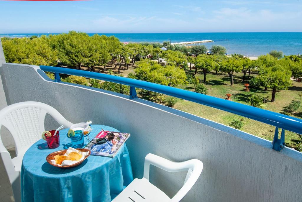 une table sur un balcon avec vue sur l'océan dans l'établissement Hotel Olimpic, à Martinsicuro