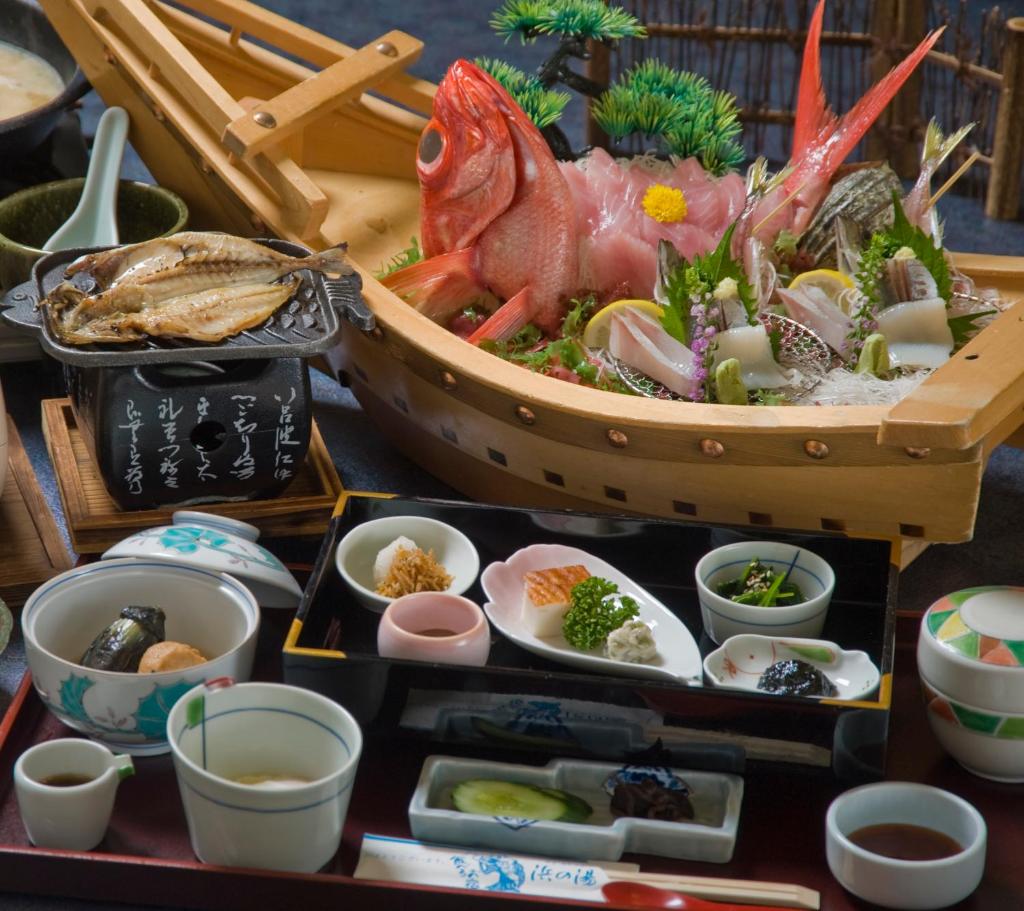 une table sur laquelle se trouvent un bol de fruits de mer et d'autres plats dans l'établissement Hamanoyu, à Higashiizu