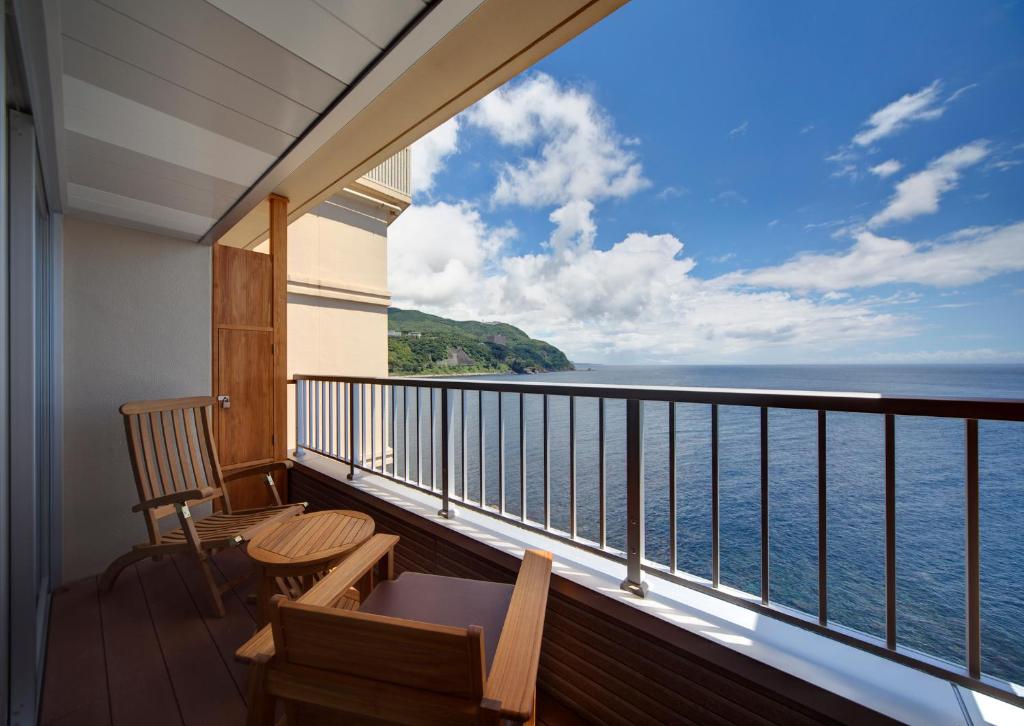 d'un balcon avec des chaises et une vue sur l'océan. dans l'établissement Hamanoyu, à Higashiizu