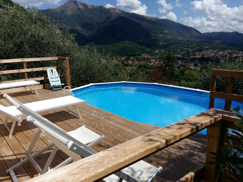 une piscine avec une terrasse, une chaise et un avisorvisor dans l'établissement Valuable rustic Tuscan swimming pool, breathtaking view of Camaiore, à Camaiore