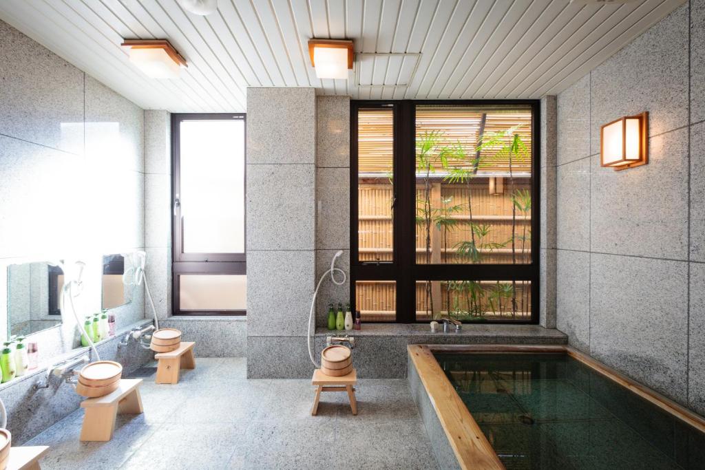 La salle de bains est pourvue d'une piscine et d'une baignoire. dans l'établissement Kyoto Ryokan Kinoe, à Kyoto