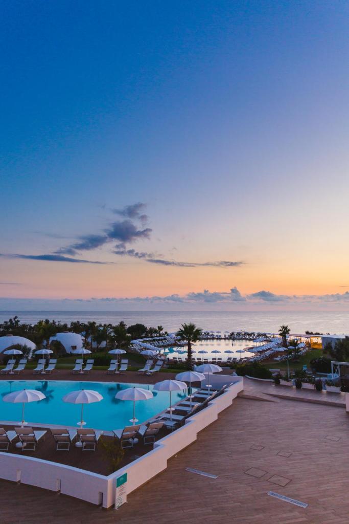 - une vue sur la piscine d'un complexe avec des chaises et des parasols dans l'établissement Torre Cintola Greenblu Sea Emotions, à Monopoli