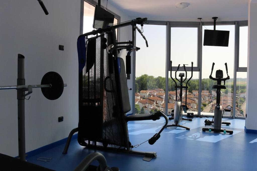 - une salle de sport avec des tapis de course et une vue sur la ville dans l'établissement Eraclea Palace Appartements, à Eraclea Mare