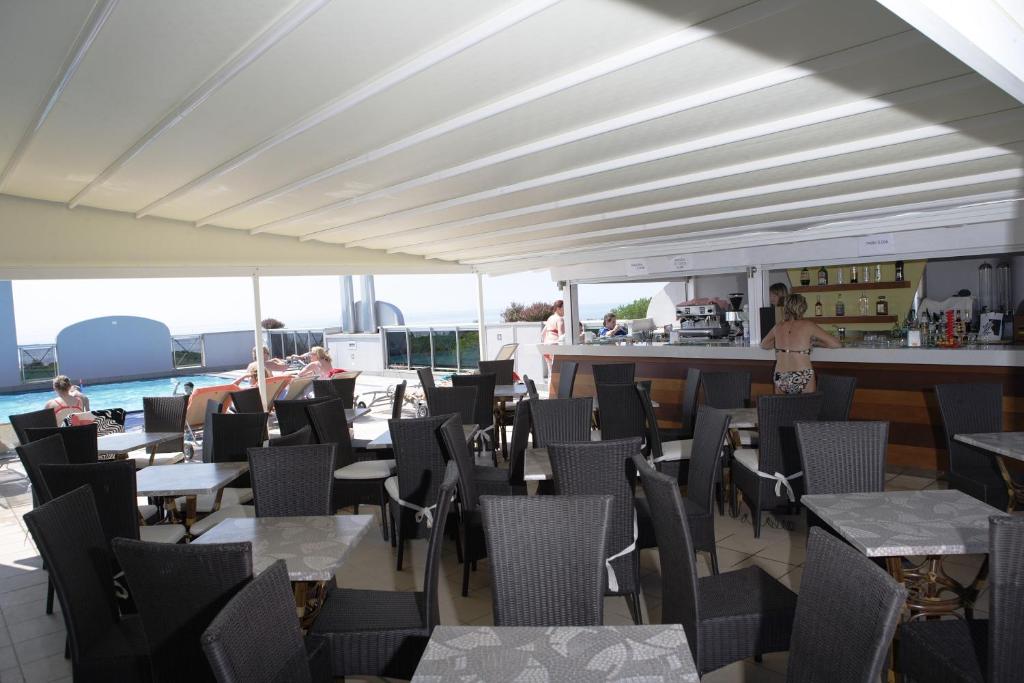 un restaurant avec des tables, des chaises et un comptoir dans l'établissement Eraclea Palace Appartements, à Eraclea Mare