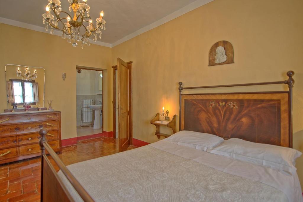 une chambre avec un lit, une commode et un miroir dans l'établissement Agriturismo Podere Delle Querci, à Castiglion Fiorentino 107 autres photos