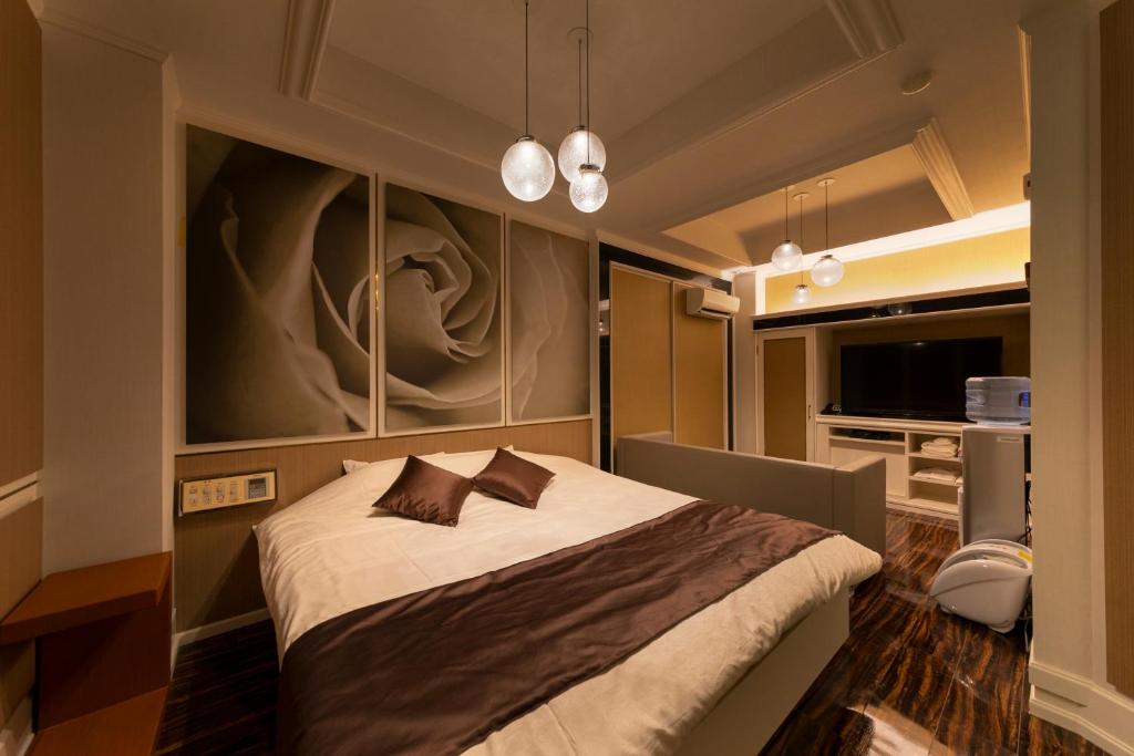 une chambre avec un lit avec un tableau sur le mur dans l'établissement Hotel Lotus Sakai (Adult Only), à Sakai
