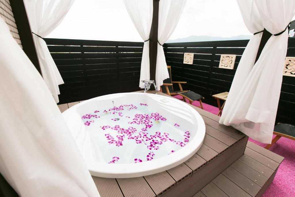une salle de bain avec une baignoire avec des fleurs roses dessus dans l'établissement Hotel Atlantis Otsu (Adult Only), à Ōtsu