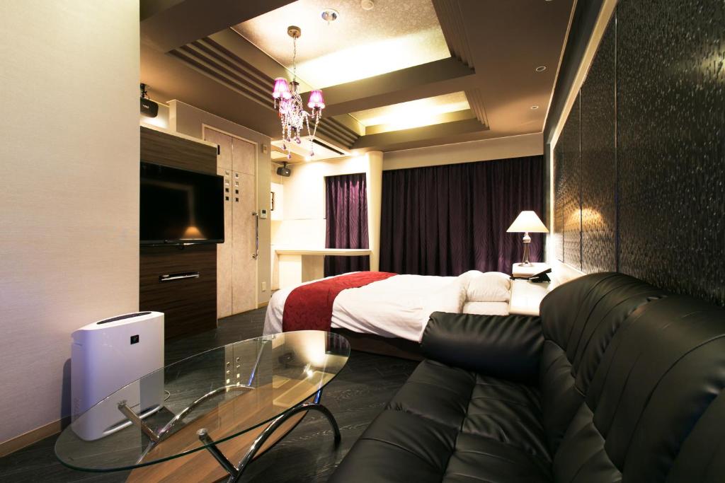 une chambre d'hôtel avec un lit et une table en verre dans l'établissement Hotel Atlantis Otsu (Adult Only), à Ōtsu