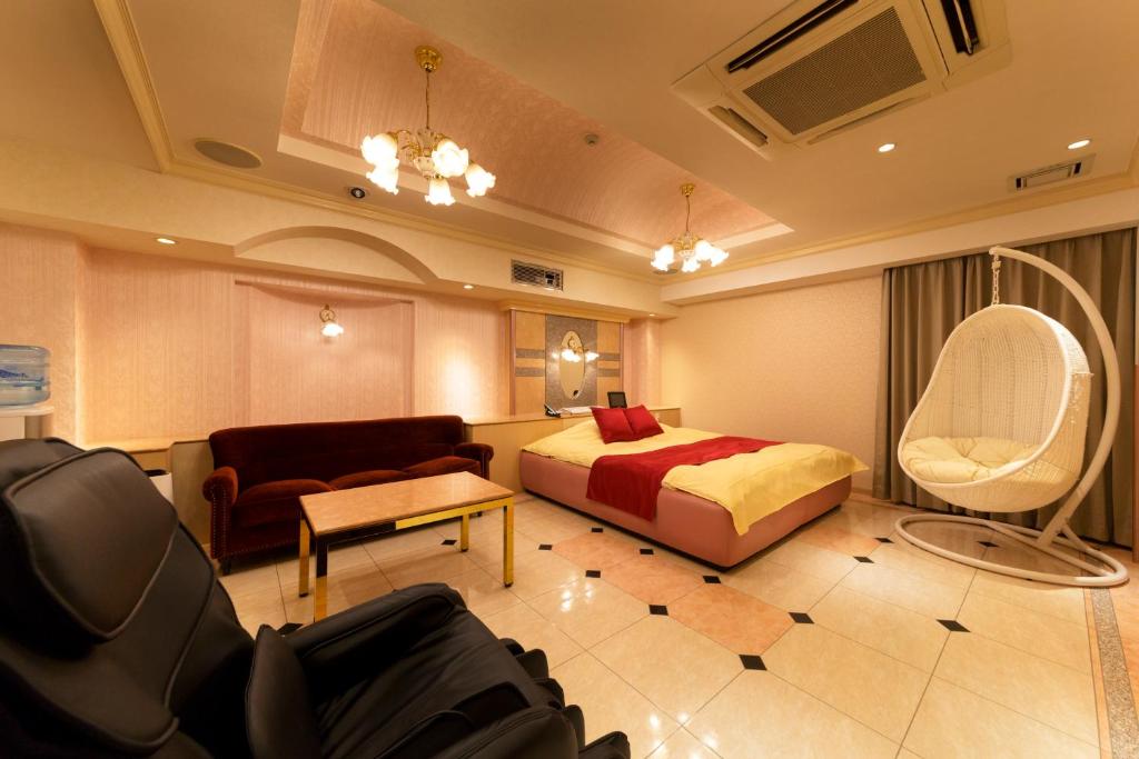 une chambre d'hôtel avec un lit et une chaise dans l'établissement Hotel Luna Ikeda (Adult Only), à Ikeda 46 autres photos