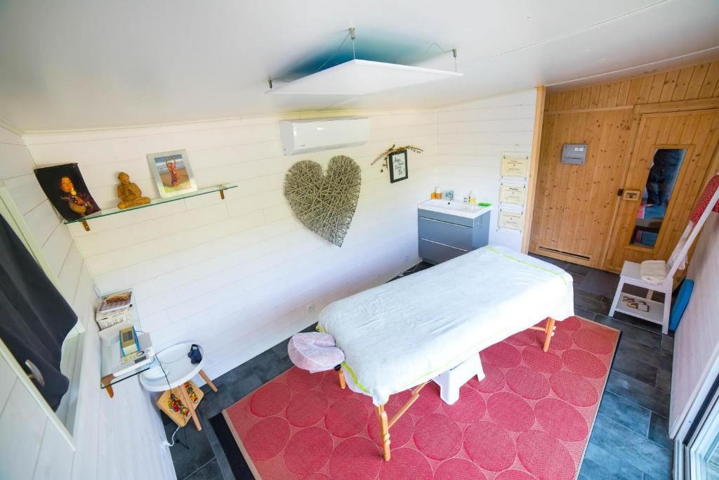 Cette chambre dispose d'un lit et d'un cœur sur le mur. dans l'établissement L'imprévu, à Vaulnaveys-le-Bas
