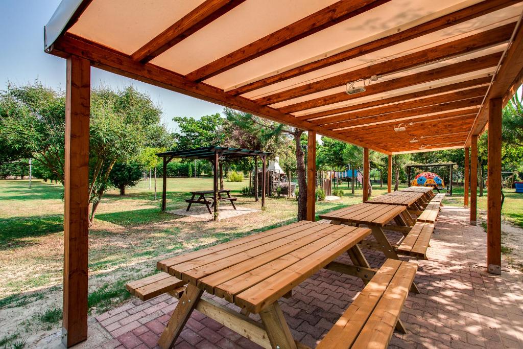 une rangée de bancs en bois dans un parc dans l'établissement Aparthotel Costa Paradiso, à Lido Adriano