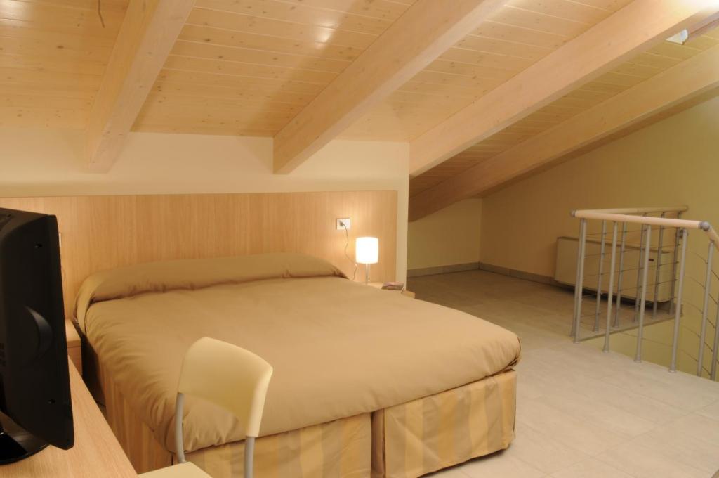 une chambre avec un lit et une télévision dans une pièce dans l'établissement Residence Belmare, à Rimini