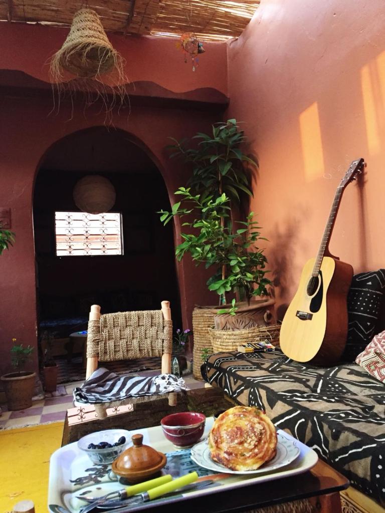 - un salon avec une guitare et une table avec de la nourriture dans l'établissement Riad Kainos, à Marrakech