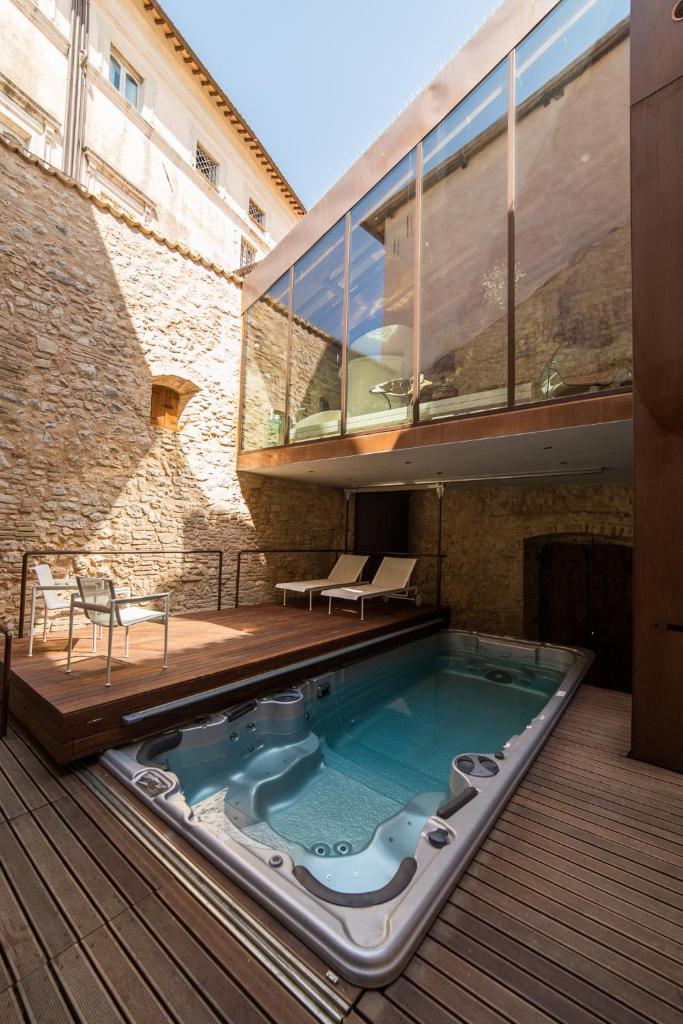 un bain à remous sur une terrasse à côté d'un bâtiment dans l'établissement Palazzo Neri, à Trevi