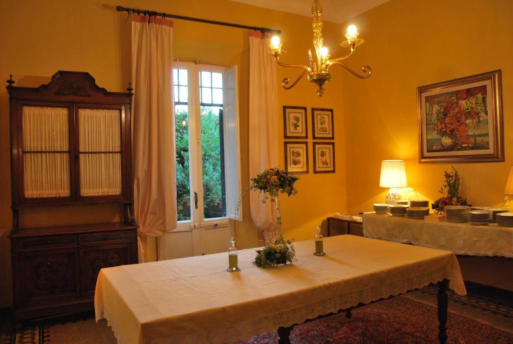 une chambre jaune avec une table et une fenêtre dans l'établissement Villa Carola, à San Giuliano Terme