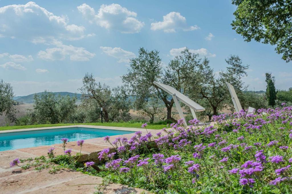 un jardin avec des fleurs violettes et une piscine dans l'établissement Villa Talosa, à Montepulciano