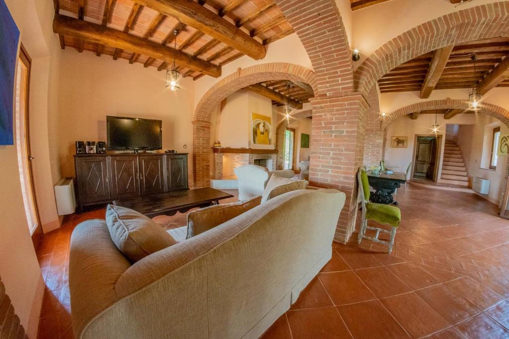 - un salon avec un canapé et une télévision dans un bâtiment dans l'établissement Villa Talosa, à Montepulciano