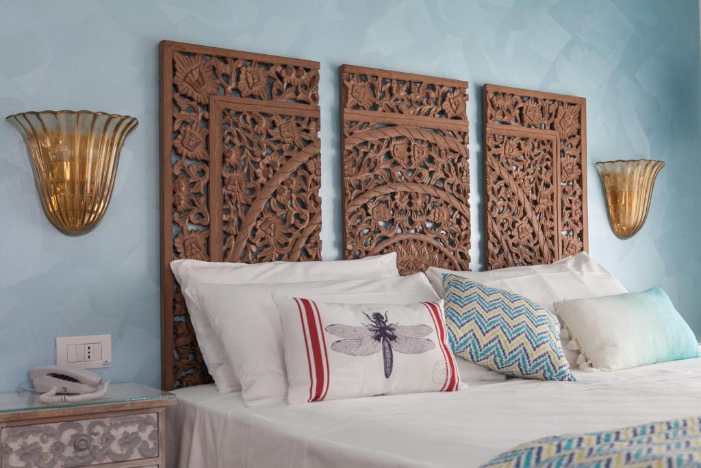 un lit avec des oreillers blancs et une tête de lit en bois dans l'établissement Hotel Albatros 3 Stelle Superior, à Lido di Jesolo