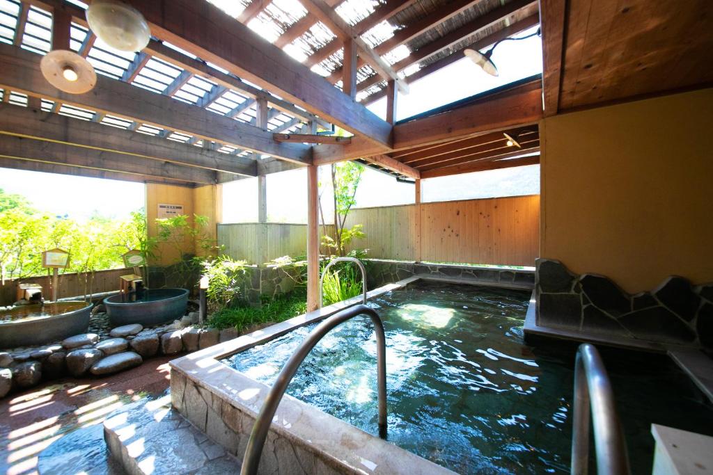 - une piscine dans un bâtiment avec un bain à remous dans l'établissement Yufuin Sansuikan, à Yufu