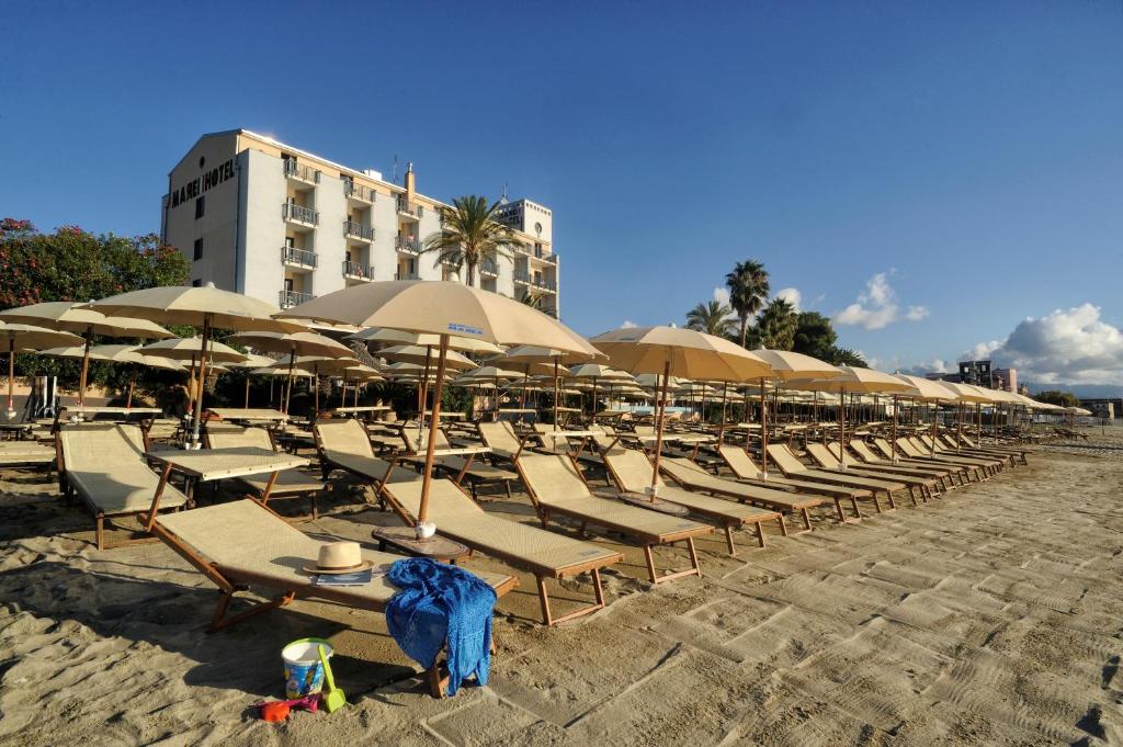 une rangée de chaises et de parasols sur une plage dans l'établissement Mare Hotel, à Savone