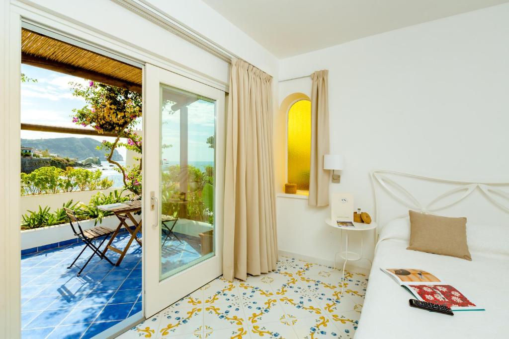 une chambre avec un lit et un balcon dans l'établissement Hotel Umberto A Mare, à Ischia