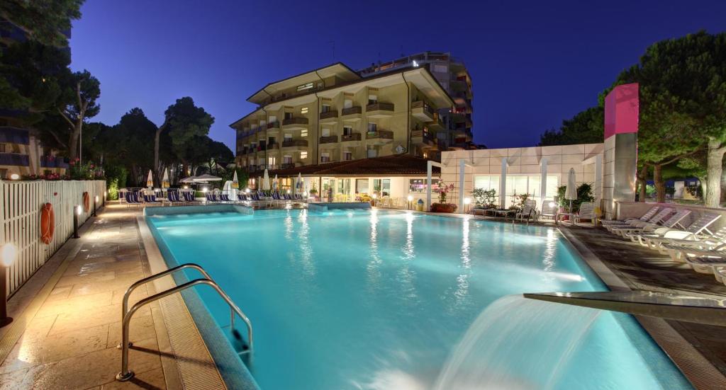 une grande piscine devant un immeuble dans l'établissement Hotel Bristol, à Lignano Sabbiadoro