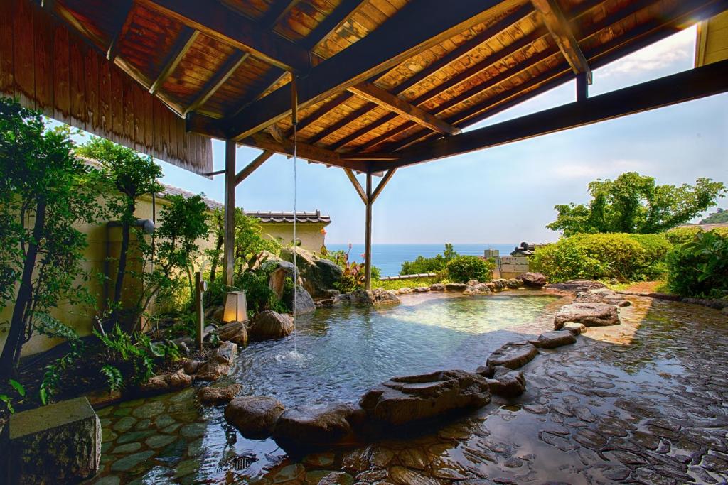 une piscine d'eau avec des rochers dans une cour dans l'établissement Atagawa Prince Hotel, à Higashiizu