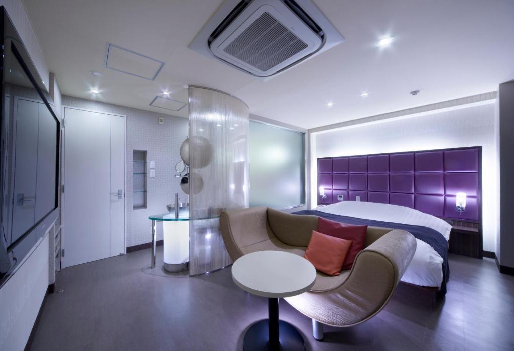 une chambre avec un lit, un canapé et une table dans l'établissement Hotel Glow Yokkaichi (Adult Only), à Yokkaichi
