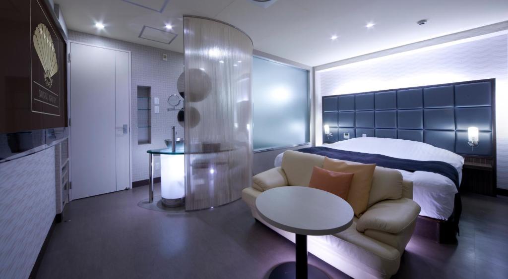 une chambre avec un lit, un canapé et une table dans l'établissement Hotel Glow Yokkaichi (Adult Only), à Yokkaichi