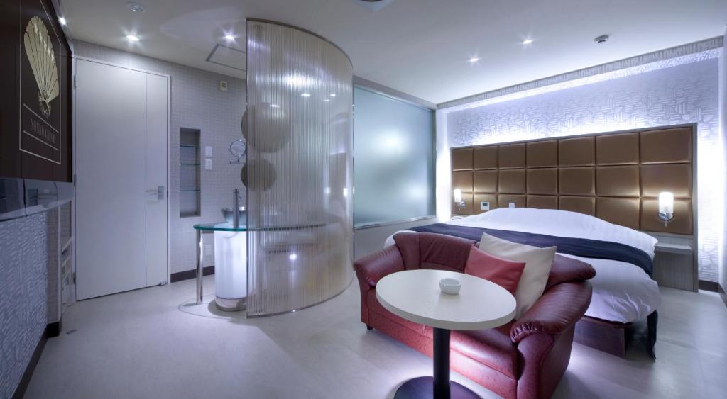 une chambre avec un lit, un canapé et une table dans l'établissement Hotel Glow Yokkaichi (Adult Only), à Yokkaichi