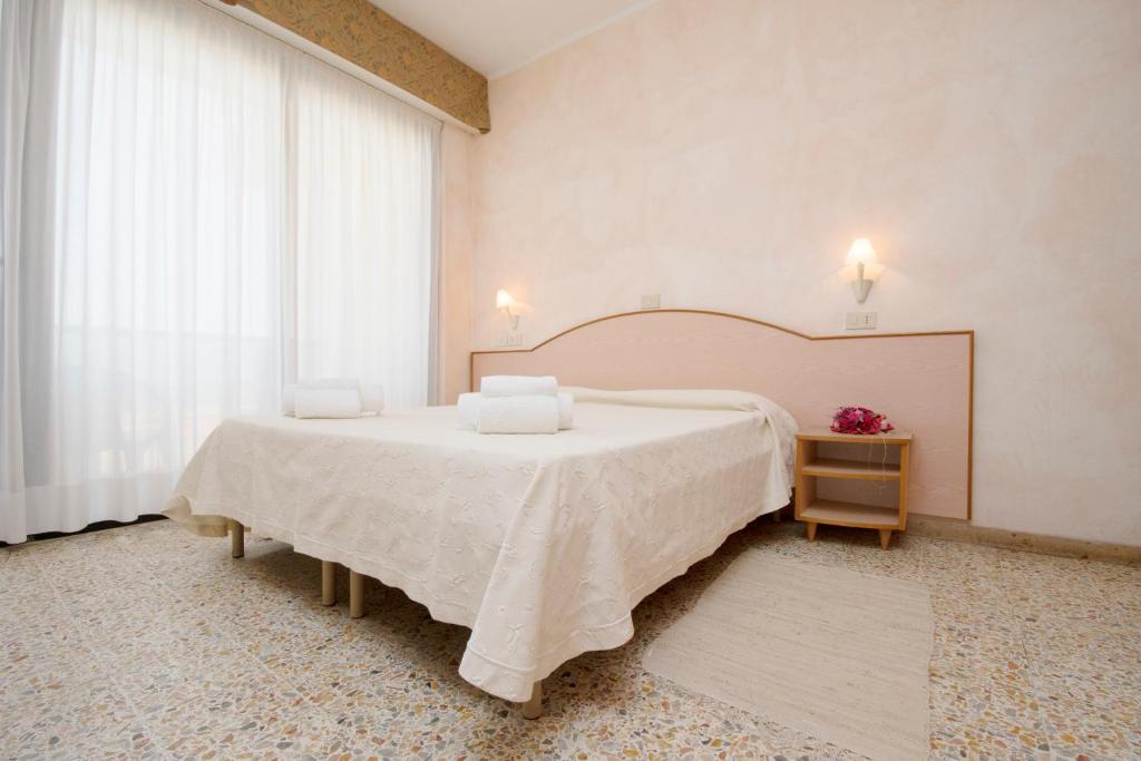 une chambre avec un grand lit et une fenêtre dans l'établissement Hotel Crown, à Rimini