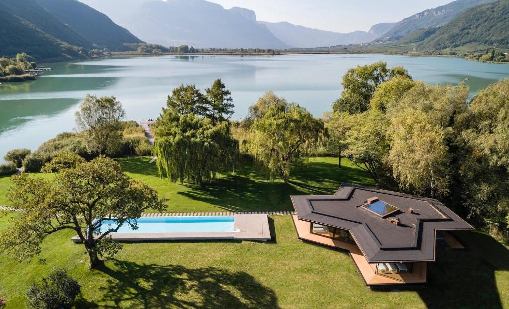 - une vue aérienne sur une maison à côté d'un lac dans l'établissement Seehotel Ambach, à Caldaro