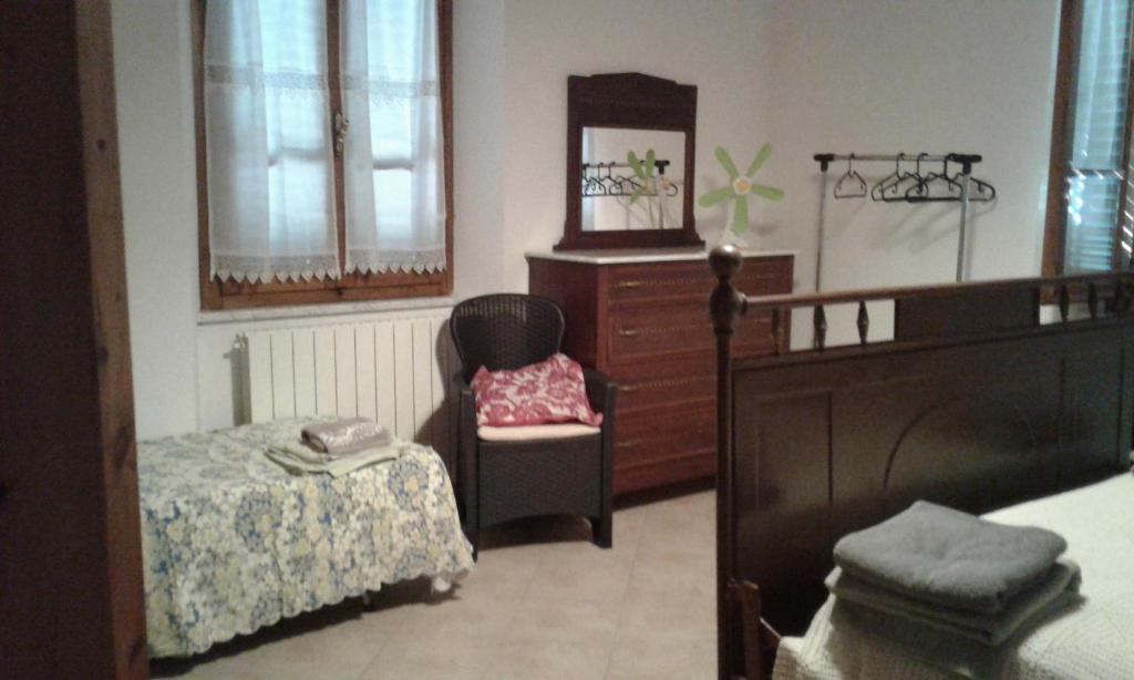 - une chambre avec un lit, une chaise et une commode dans l'établissement CA' MENEGHETTI, à Massaciuccoli