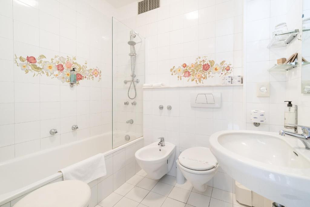 une salle de bain blanche avec toilettes et lavabo dans l'établissement Grand Hotel Don Juan, à Giulianova
