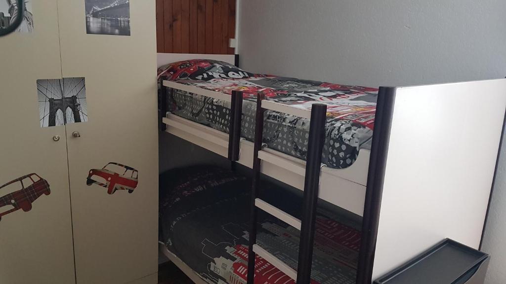 Ce lit superposé se trouve dans une petite chambre avec un lit. dans l'établissement Studio-cabine au pied des pistes à Super Besse, à Super-Besse