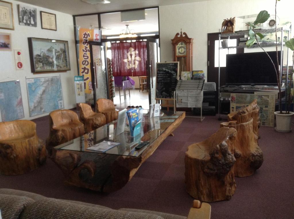 - un salon avec une table, des chaises et une télévision dans l'établissement Ryounkaku, à Kami-furano
