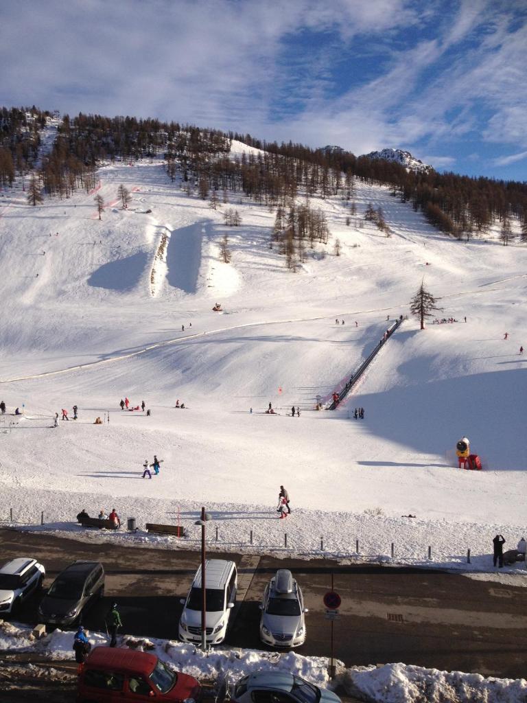 un groupe de personnes skier sur une piste enneigée dans l'établissement Face aux pistes, à Montgenèvre