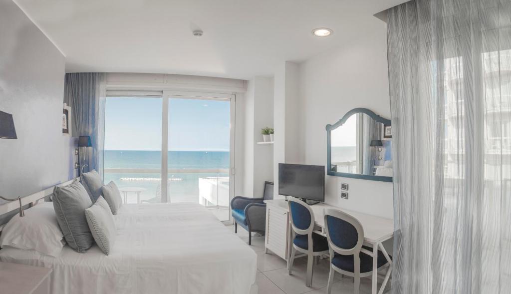 une chambre blanche avec un lit et un bureau avec un ordinateur dans l'établissement Hotel Sans Souci, à Gabicce Mare