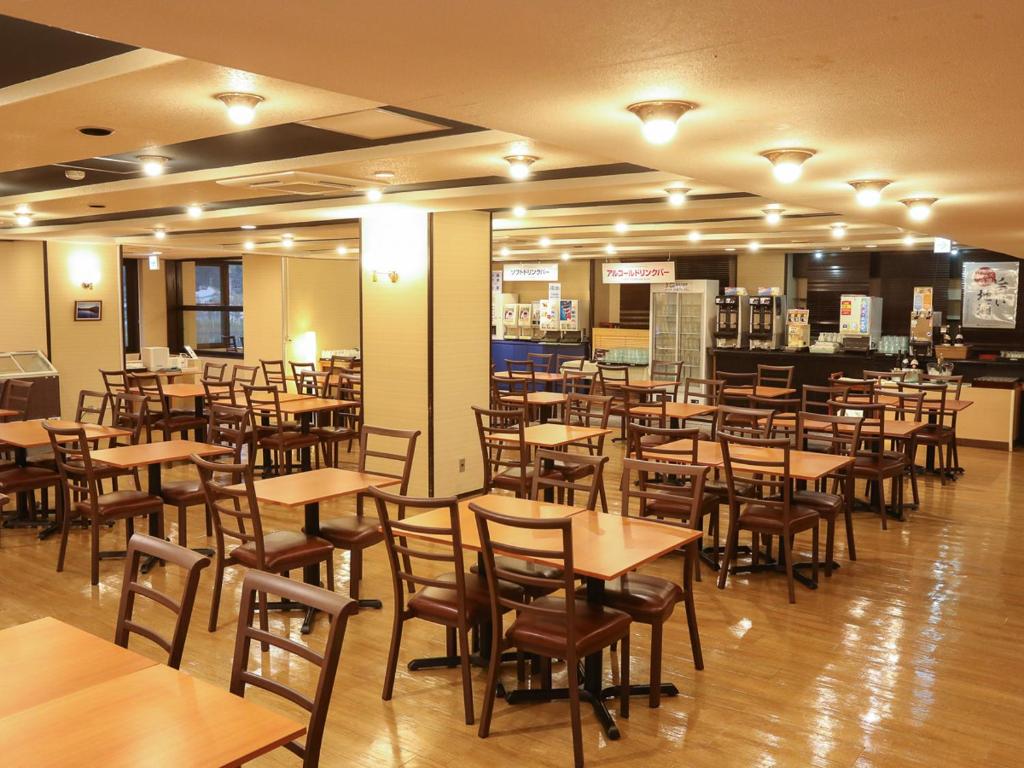 un restaurant rempli de tables et de chaises en bois dans l'établissement Shirakabako View Hotel, à Tateshina